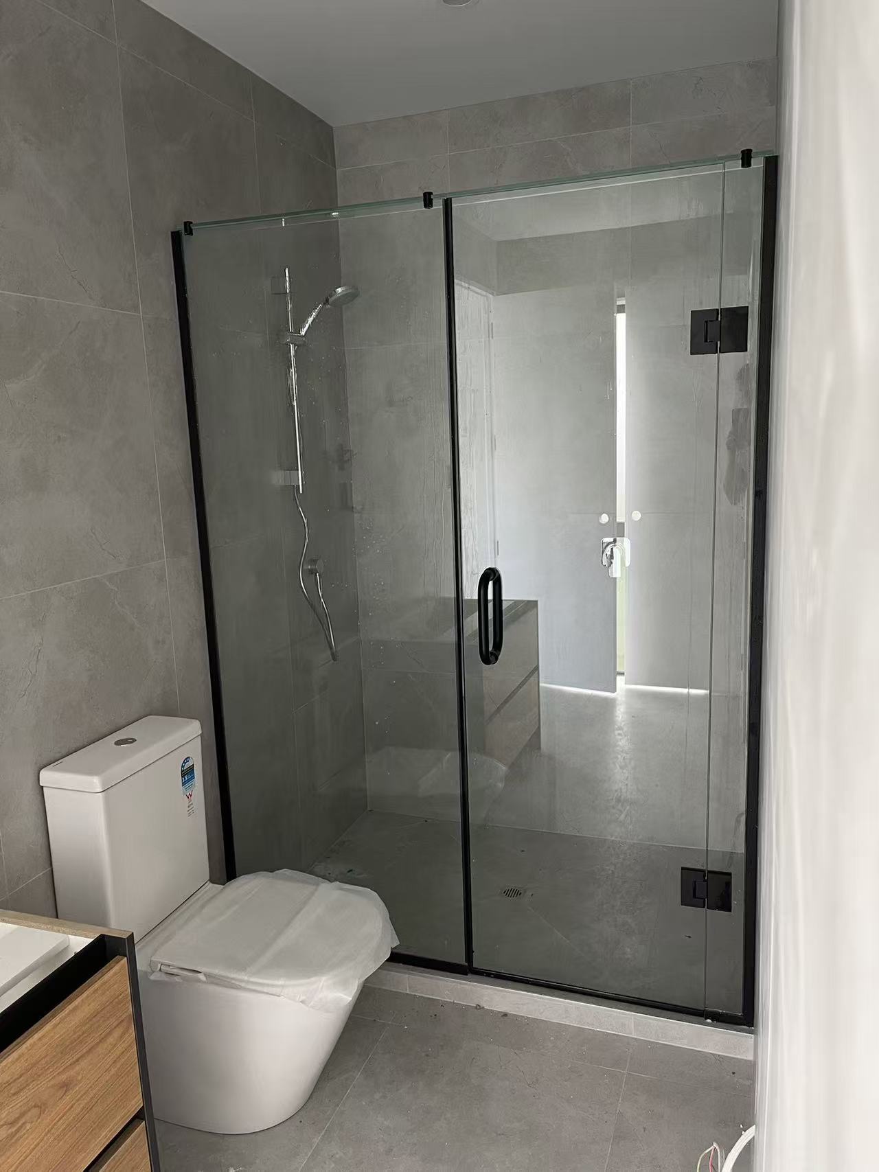 Shower enclosure with black channel, hinges and handle