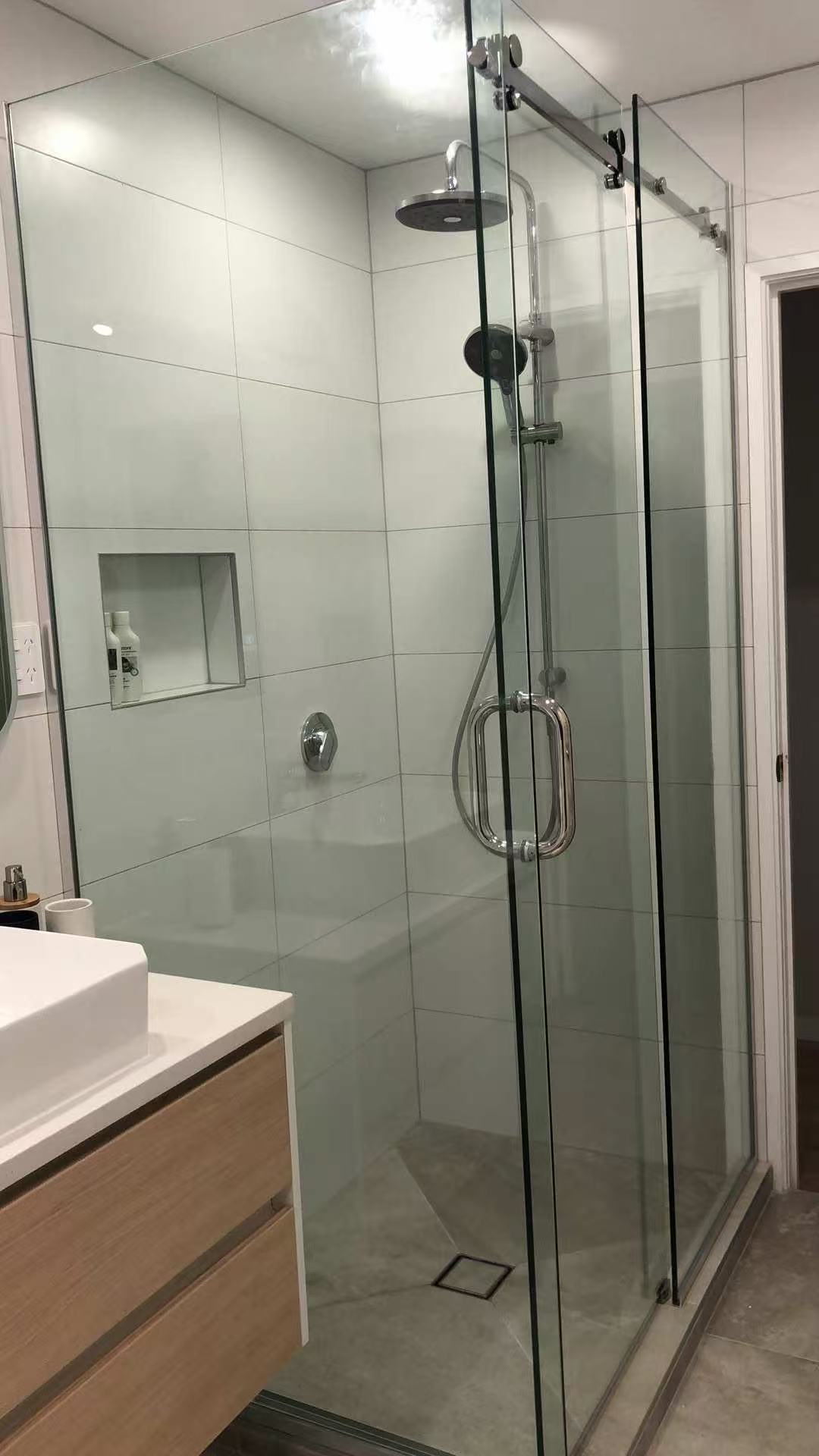 Sliding glass shower enclosure with polished chrome hardware