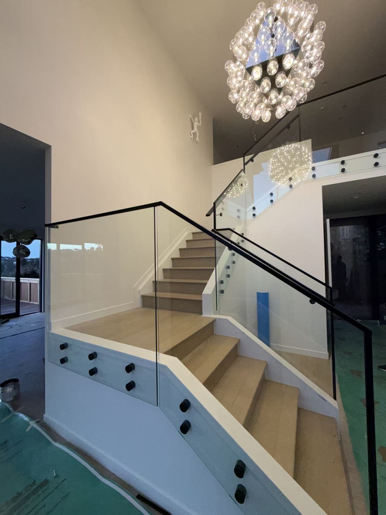 Multi-level glass stair balustrade with black handrails